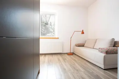 a living room with a white couch and a window at Apartament z ogrodem w centrum Limanowej in Limanowa