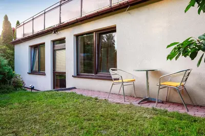 two chairs and a table in front of a house at Apartament z ogrodem w centrum Limanowej in Limanowa