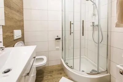 a white bathroom with a shower and a sink at BABIOGÓRSKA B&B in Zubrzyca Górna