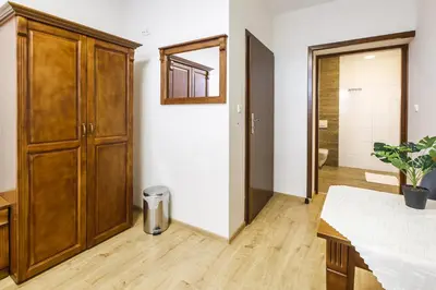 a room with a large wooden cabinet and a bathroom at BABIOGÓRSKA B&B in Zubrzyca Górna