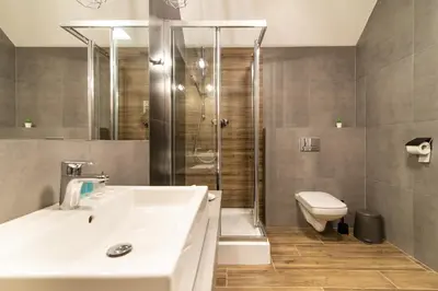 a bathroom with a sink and a shower and a toilet at Ostoja Garden in Brody