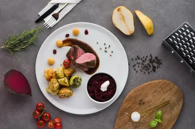 a plate of food with meat and vegetables on a table at Ostoja Garden in Brody