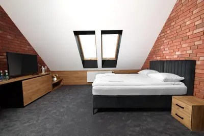a bedroom with a bed and a brick wall at Ostoja Garden in Brody