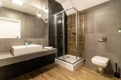 a bathroom with a sink and a shower and a toilet at Ostoja Garden in Brody