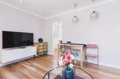 a living room with a tv and a vase of flowers at Apartament przy Bulwarach Wiślanych Kościuszki by Noclegi Renters in Kraków