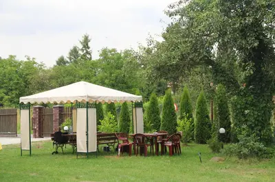 a table and chairs under an umbrella in a yard at Willa Kryspinów in Kraków