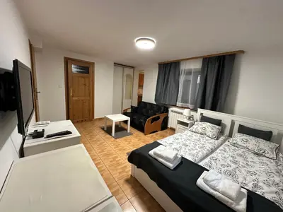 a bedroom with a bed and a living room at Willa Kryspinów in Kraków