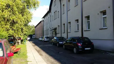 a street with cars parked on the side of a building at Street Art Apartment in Oświęcim