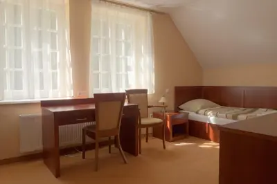 a bedroom with a bed and a desk and chairs at Pokoje Gościnne Pałac w Balicach Instytut Zootechniki PIB in Balice