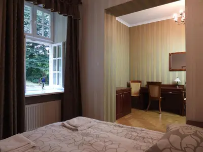 a bedroom with a bed and a desk and a window at Pokoje Gościnne Pałac w Balicach Instytut Zootechniki PIB in Balice