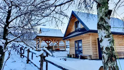 a wooden house with snow on the roof at Domki w górach Na Grapie in Stryszawa