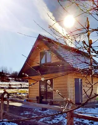 a small wooden house with the sun shining on it at Domki w górach Na Grapie in Stryszawa