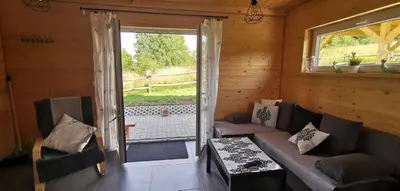 a living room with a couch and a sliding glass door at Domki w górach Na Grapie in Stryszawa