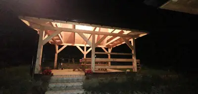 a wooden gazebo at night with the lights on at Domki w górach Na Grapie in Stryszawa