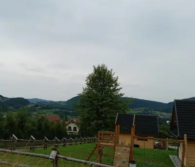 a view of a farm with a wooden playground at Domki w górach Na Grapie in Stryszawa