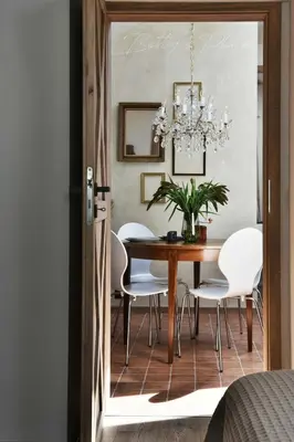 a dining room table with white chairs and a chandelier at Betty's Place in Zabierzów