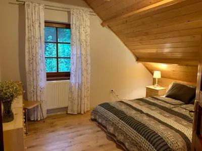 a bedroom with a bed and a large window at Dom Na Wzgórzu 479, The House on the hill in Sułkowice