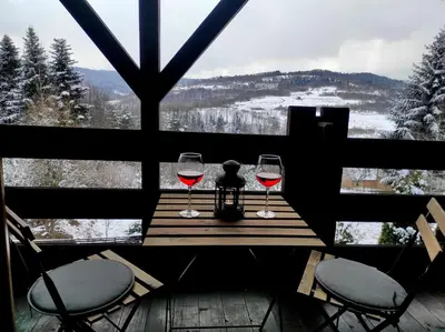 two glasses of wine sitting on a table in front of a window at Dom Na Wzgórzu 479, The House on the hill in Sułkowice