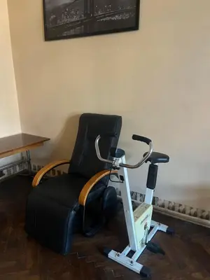 a black chair sitting in a room with a treadmill at Adam12 in Kraków