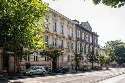 a large building with cars parked in front of it at Adam12 in Kraków