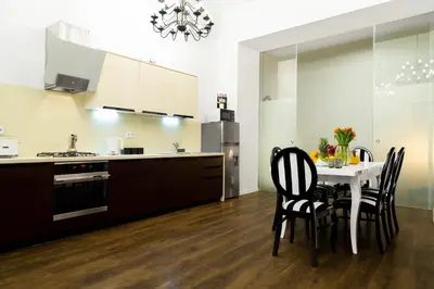a kitchen with a table and chairs in a kitchen at HOUSEHOST Apartment: Bogusławskiego Street in Kraków