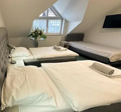 a attic room with three beds and a window at Hotel Arkadia in Klecza Górna