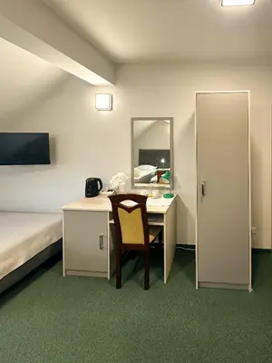 a room with a desk and a bed and a mirror at Hotel Arkadia in Klecza Górna