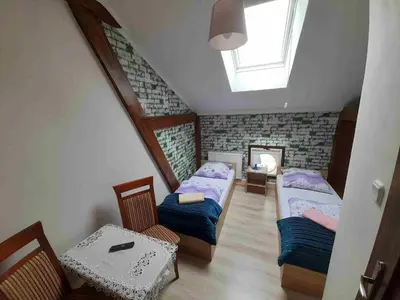 a attic room with two beds and a table at Kraków Hostel in Kraków