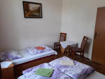 a room with two beds and two tables and chairs at Kraków Hostel in Kraków