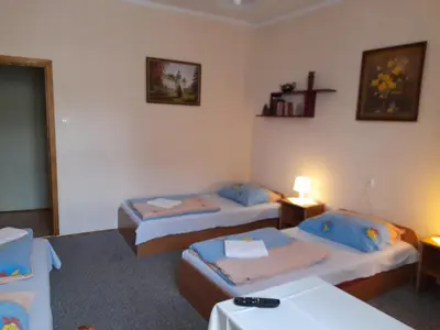 a room with two beds and a table with a lamp at Kraków Hostel in Kraków