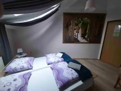 a bedroom with two beds with purple and blue pillows at Kraków Hostel in Kraków