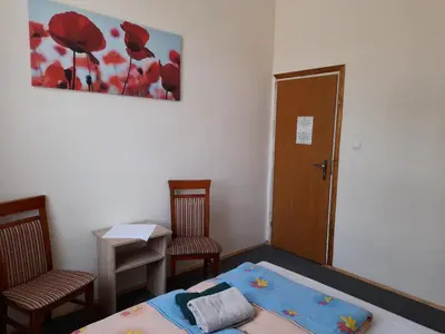 a room with a bed and two chairs and a door at Kraków Hostel in Kraków