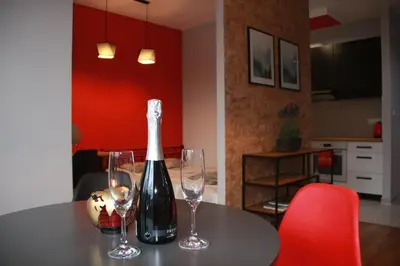 a bottle of wine sitting on a table with two glasses at Niko Apartments 1 in Kraków