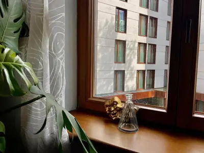 a glass bottle sitting on a window sill next to a plant at Old Town Krakow! Amazing location & character in Kraków