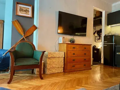 a living room with a tv and a chair and a dresser at Old Town Krakow! Amazing location & character in Kraków