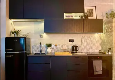 a kitchen with a black refrigerator and brown cabinets at Old Town Krakow! Amazing location & character in Kraków