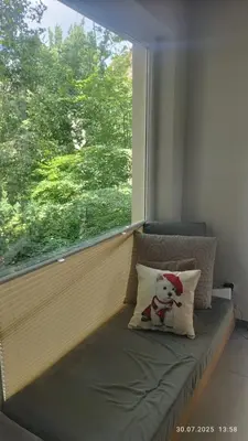 a teddy bear sitting on a pillow in a window at Apartament Lena Stare Miasto in Kraków