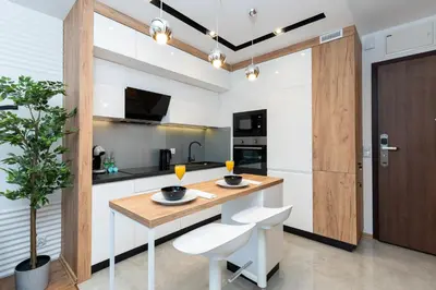 a kitchen with a wooden table and white chairs at Comfort, prestige, best location Romanowicza 1 in Kraków