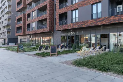 a building with chairs and tables in front of it at Comfort, prestige, best location Romanowicza 1 in Kraków