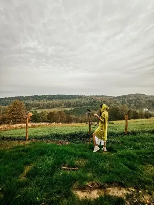 a man taking a picture of a field with a camera at LushHills - Nowoczesna Jurta in Regulice