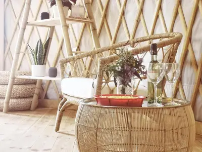 a room with a chair with a table and wine glasses at LushHills - Nowoczesna Jurta in Regulice