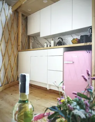 a room with a bottle of wine and a kitchen at LushHills - Nowoczesna Jurta in Regulice