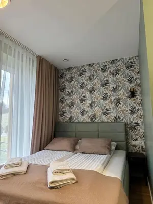 a bedroom with two beds and a large window at Trzy Małe Drzewka in Wielka Wieś