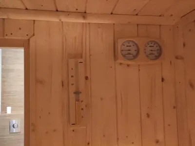 a room with wooden walls with two clocks on the wall at Trzy Małe Drzewka in Wielka Wieś
