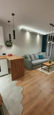 a living room with a couch and a table at APARTAMENT DĄBSKA 24 TAURON ARENA in Kraków