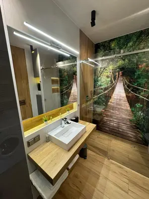 a bathroom with a sink and a painting of a bridge at APARTAMENT DĄBSKA 24 TAURON ARENA in Kraków