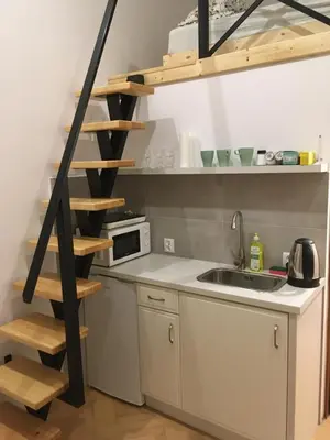 a kitchen with a sink and a spiral staircase at Main Square Apartaments in Kraków