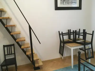 a staircase with chairs and a table in a room at Main Square Apartaments in Kraków