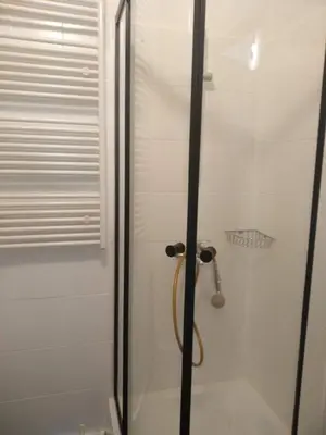a bathroom with a shower with a glass door at Main Square Apartaments in Kraków