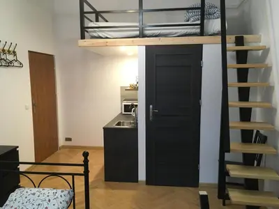 a room with a bunk bed and a staircase at Pure Apartments in Kraków